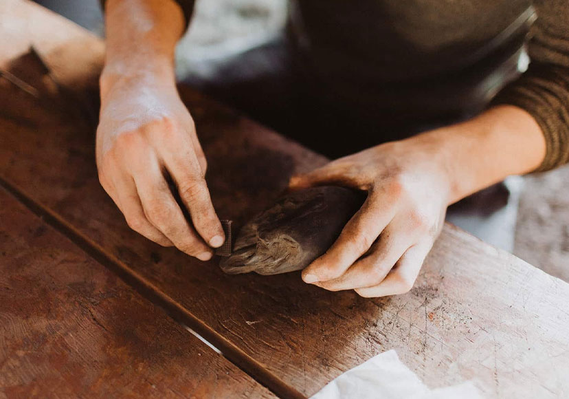 Man sanding a sculpture at Celtic Roots Studio.